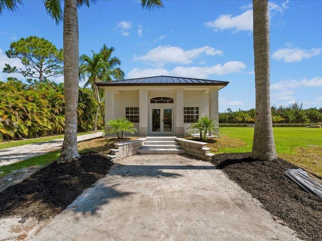 view of front of home featuring a front lawn and french doors