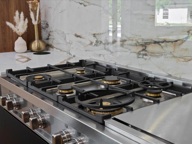 room details with stainless steel gas stovetop and backsplash