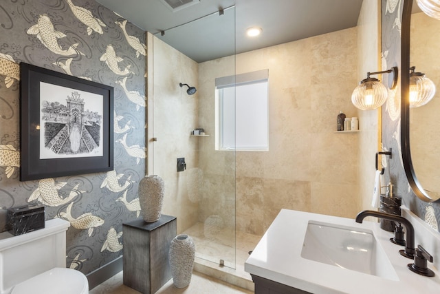 bathroom featuring vanity, toilet, and a tile shower