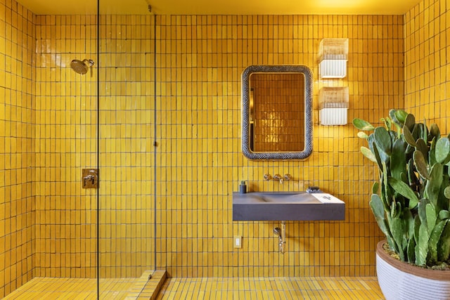 bathroom featuring tiled shower and sink