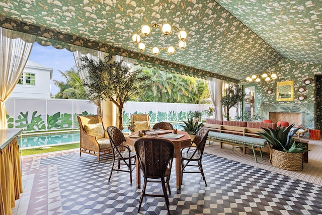 sunroom / solarium featuring a chandelier