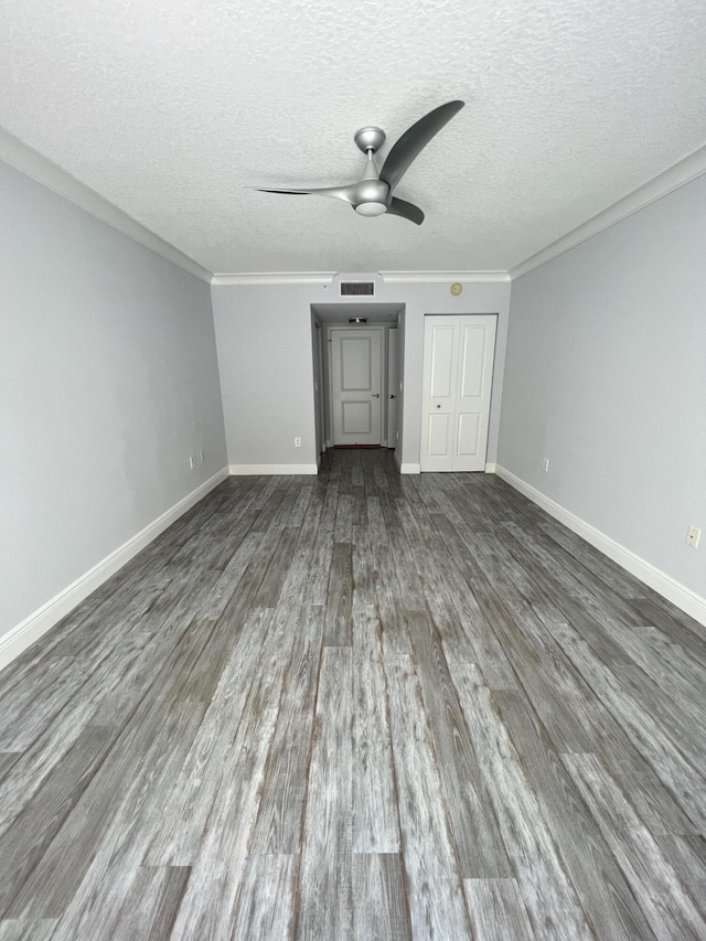 unfurnished bedroom featuring wood-type flooring, ornamental molding, ceiling fan, and a textured ceiling