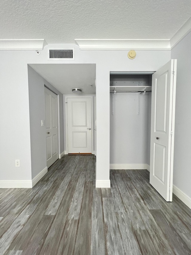 unfurnished bedroom featuring wood-type flooring, a closet, and a textured ceiling