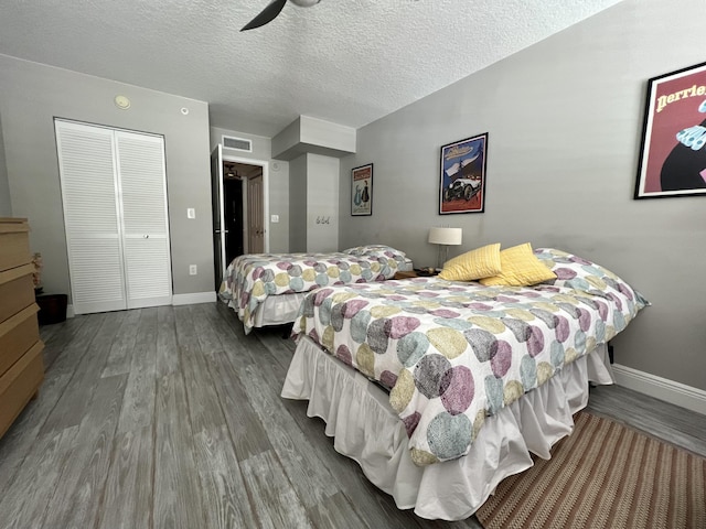 bedroom with wood-type flooring, a closet, and a textured ceiling