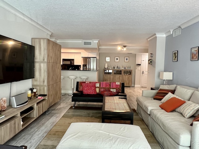 living room with crown molding, a textured ceiling, and hardwood / wood-style flooring