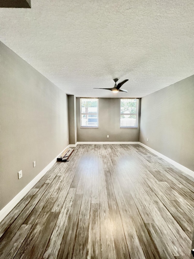 spare room featuring ceiling fan, wood-type flooring, and a textured ceiling