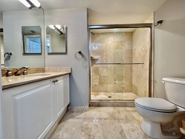 bathroom with vanity, a shower with door, and toilet