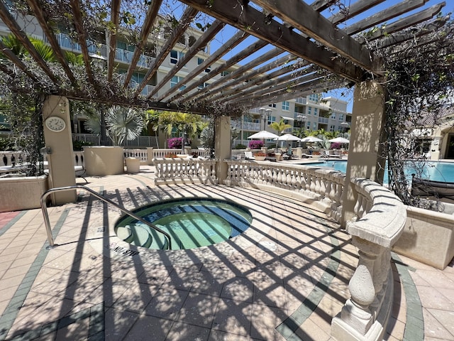 view of swimming pool featuring a hot tub, a pergola, and a patio area