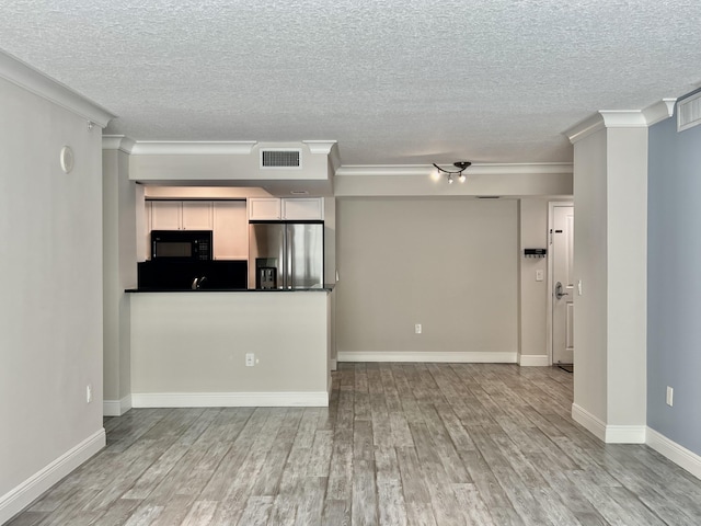 unfurnished living room with crown molding and light wood-type flooring