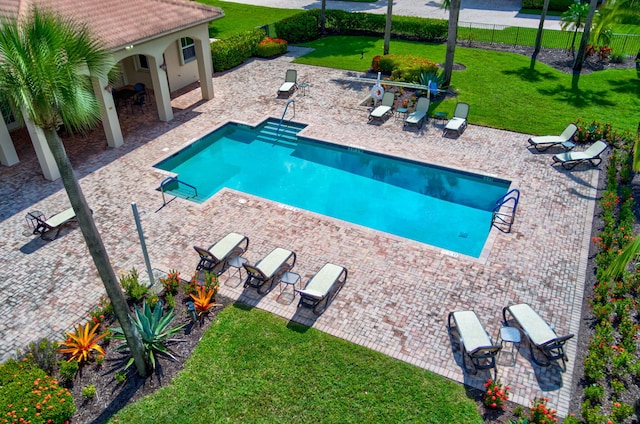 view of pool with a patio area and a lawn