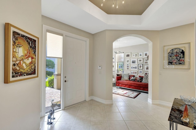 tiled entryway with a raised ceiling