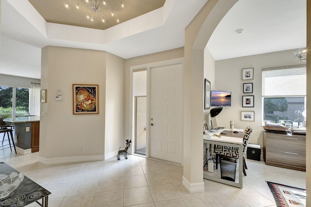 entryway featuring light tile patterned floors and a raised ceiling