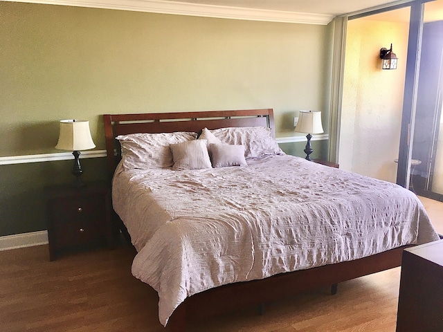 bedroom with wood-type flooring and ornamental molding