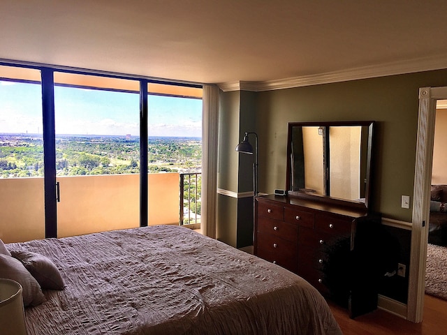 bedroom featuring wood-type flooring, access to outside, and ornamental molding