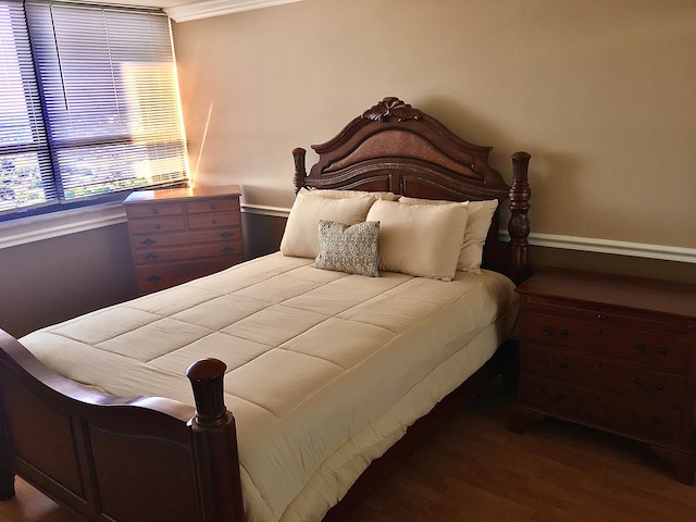 bedroom featuring wood-type flooring and crown molding