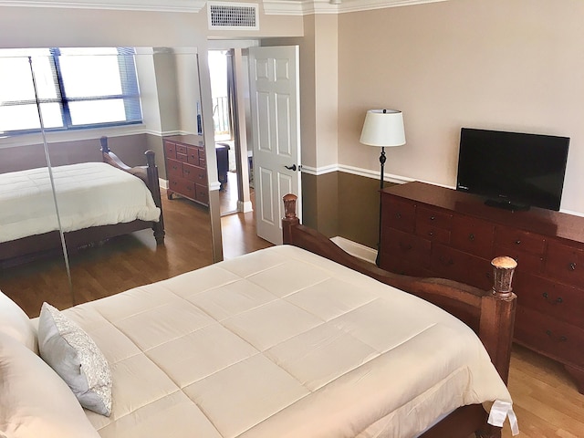 bedroom with wood-type flooring and ornamental molding