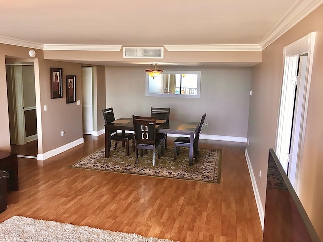 dining room featuring dark hardwood / wood-style flooring and ornamental molding