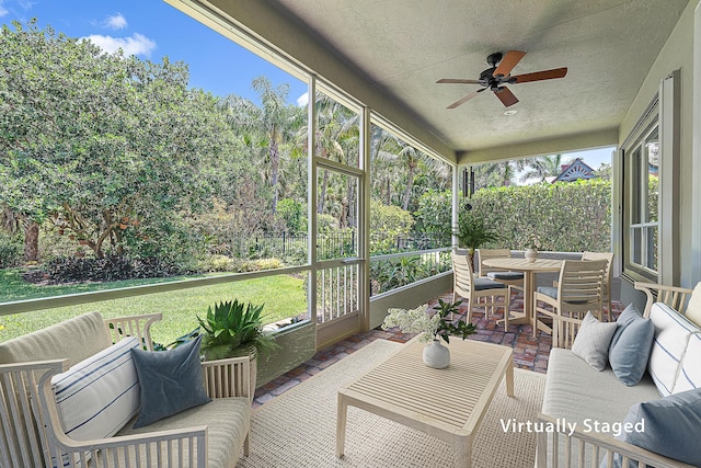 sunroom / solarium with a ceiling fan