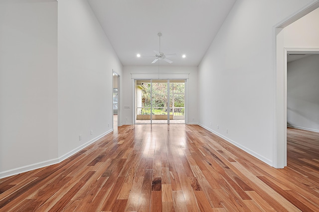 unfurnished room featuring light wood-type flooring, high vaulted ceiling, ceiling fan, and baseboards