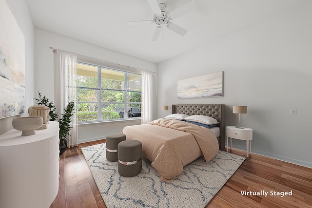 bedroom with dark wood finished floors, a ceiling fan, and baseboards