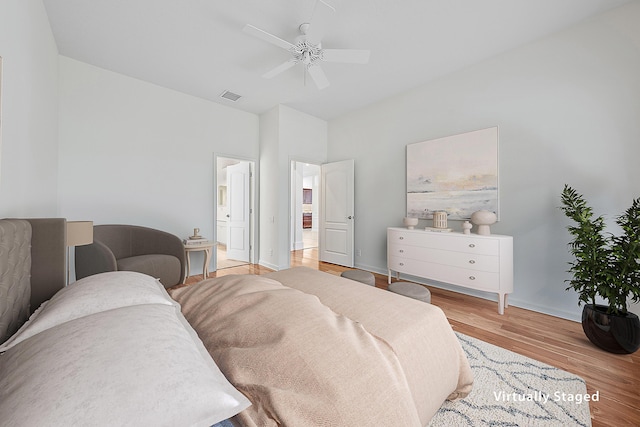 bedroom featuring visible vents, baseboards, a ceiling fan, ensuite bath, and light wood-style flooring