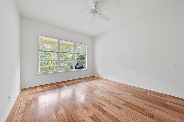 unfurnished room with ceiling fan, light wood-type flooring, and baseboards