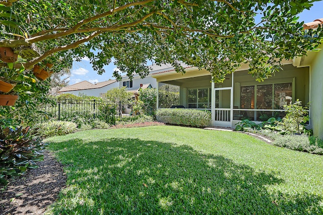 view of yard with fence and a sunroom