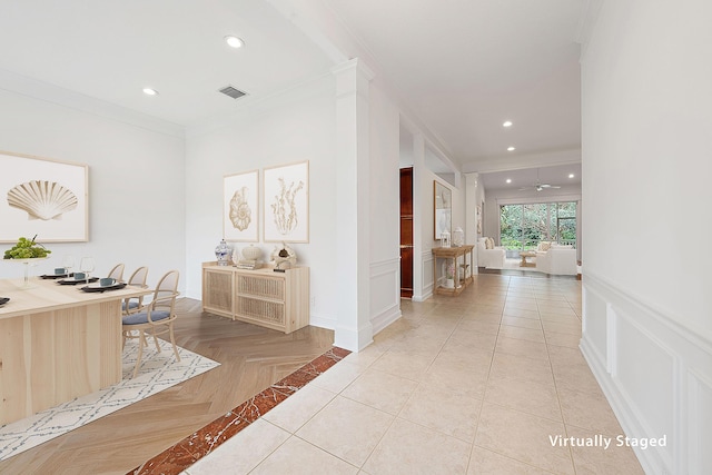 corridor with visible vents, a decorative wall, crown molding, and recessed lighting