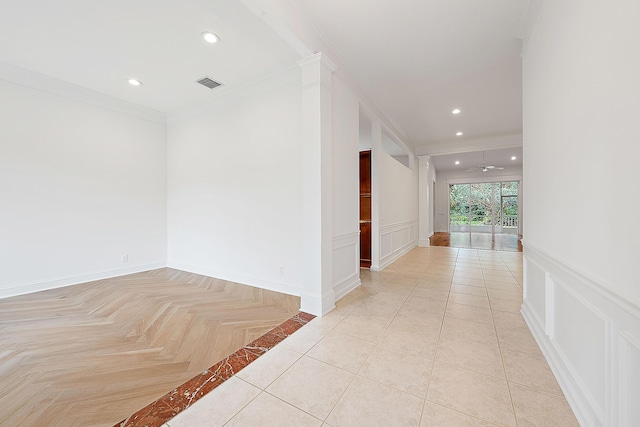 hall with visible vents, a decorative wall, crown molding, and recessed lighting