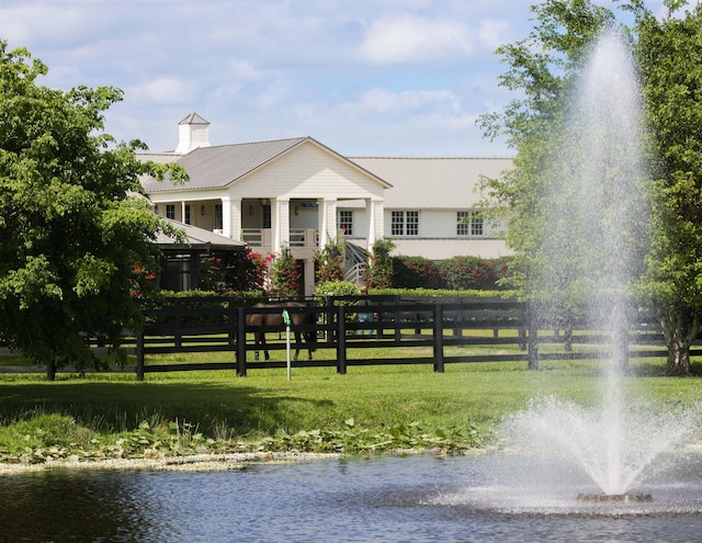 view of front of home featuring a water view and a front lawn