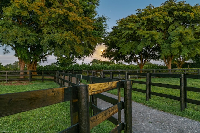 gate at dusk featuring a yard