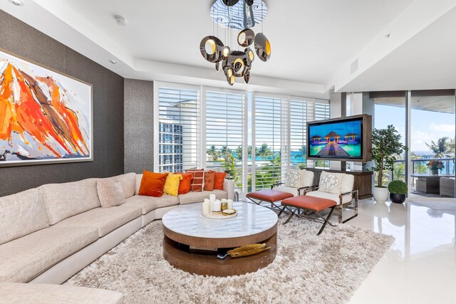 living room with plenty of natural light, a notable chandelier, and a wall of windows