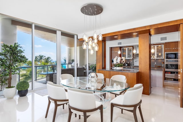 tiled dining space featuring a wall of windows, sink, and a notable chandelier