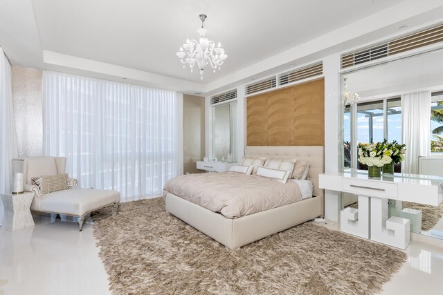 bedroom featuring an inviting chandelier and a raised ceiling