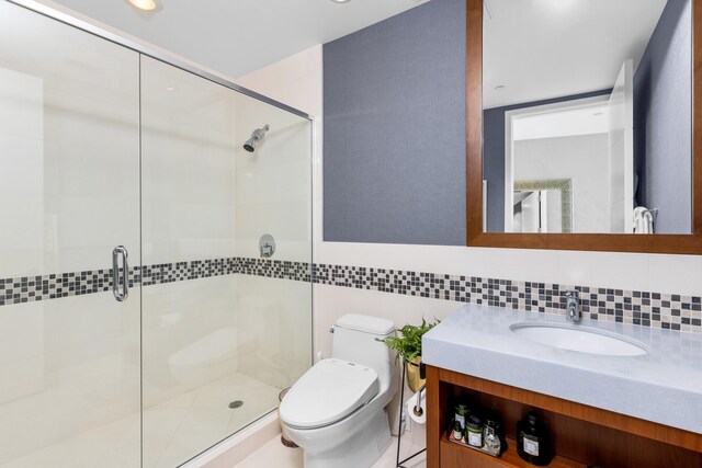 bathroom featuring tile walls, an enclosed shower, vanity, and toilet