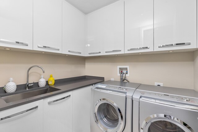 washroom with sink, cabinets, and washing machine and clothes dryer