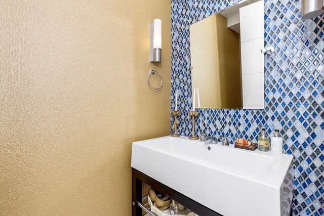 bathroom with sink and decorative backsplash