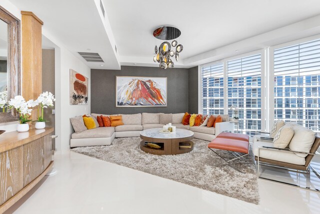 living room featuring an inviting chandelier and a wall of windows