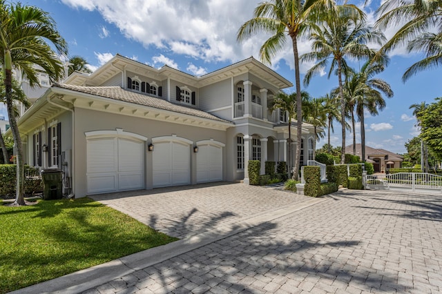 mediterranean / spanish-style home featuring a balcony, a garage, and a front lawn