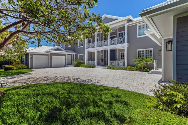 view of front of home featuring a balcony, a garage, and a front lawn