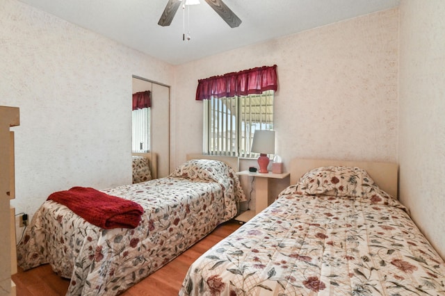 bedroom with wood-type flooring, ceiling fan, and a closet