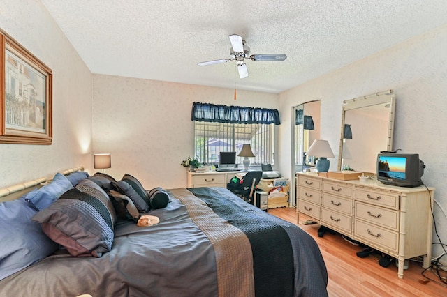 bedroom featuring ceiling fan, a textured ceiling, and light wood-type flooring