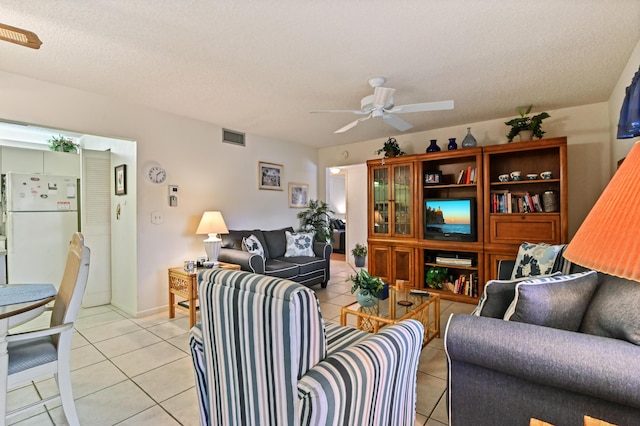 tiled living room with ceiling fan and a textured ceiling