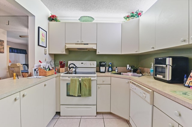 kitchen with sink, white cabinets, and white appliances