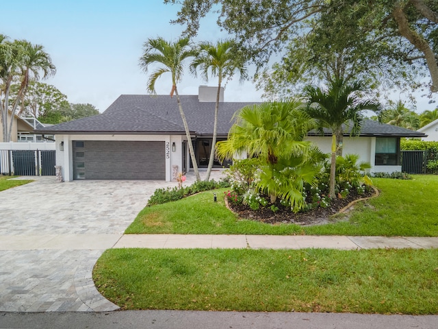 ranch-style home featuring a front lawn and a garage