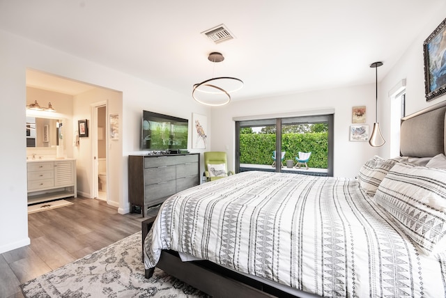 bedroom with wood-type flooring and connected bathroom