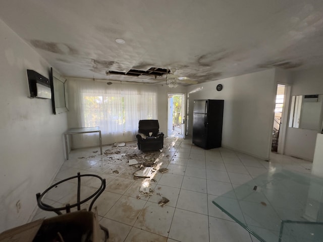 unfurnished living room with ceiling fan, light tile patterned flooring, and a healthy amount of sunlight