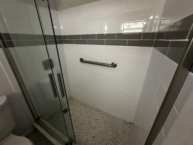 bathroom featuring an enclosed shower and toilet