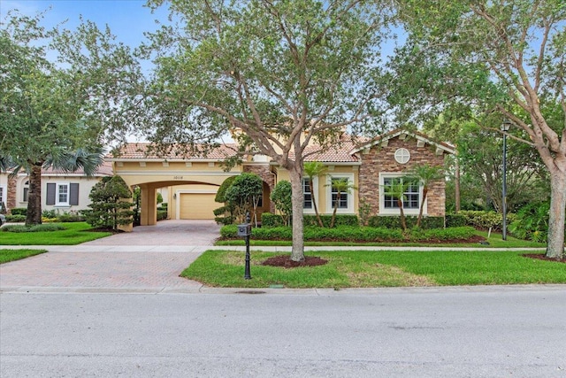 mediterranean / spanish house with a front lawn and a garage