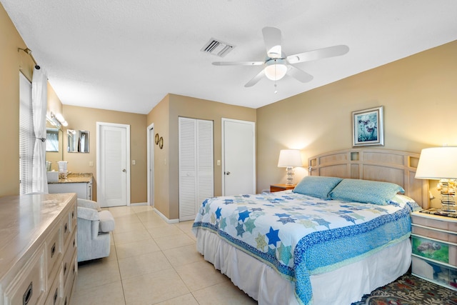 tiled bedroom with a textured ceiling and ceiling fan